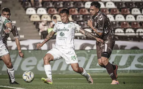 Franco Frías, de Sarmiento, se lleva la pelota ante el asedio de un defensor calamar.