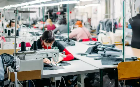 Una trabajadora textil continúa su labor en el taller, mientras los números del sector se tiñen de rojo.