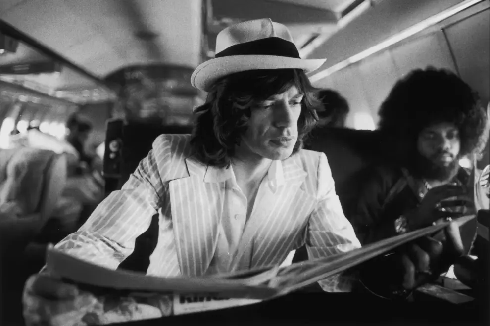 Mick Jagger lee el periódico en el avión privado de los Rolling Stones