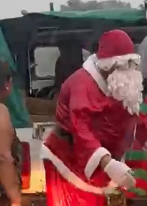 Papá Noel entregando regalos en medio de la lluvia