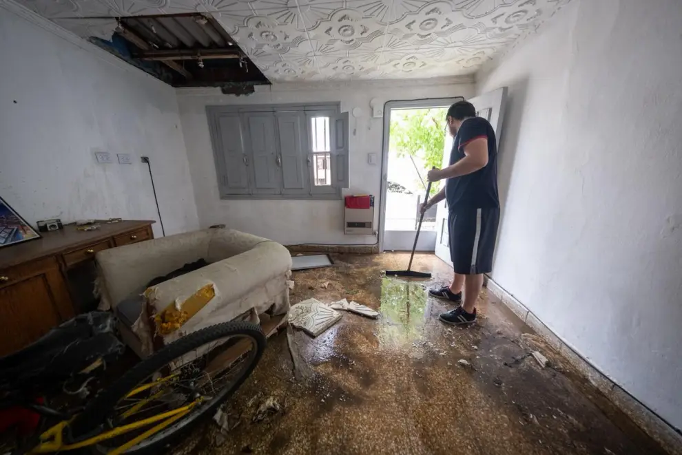 Vecino, cuyo techo colapsó, saca el agua de su casa. Fotografía: Javier Corbalán.