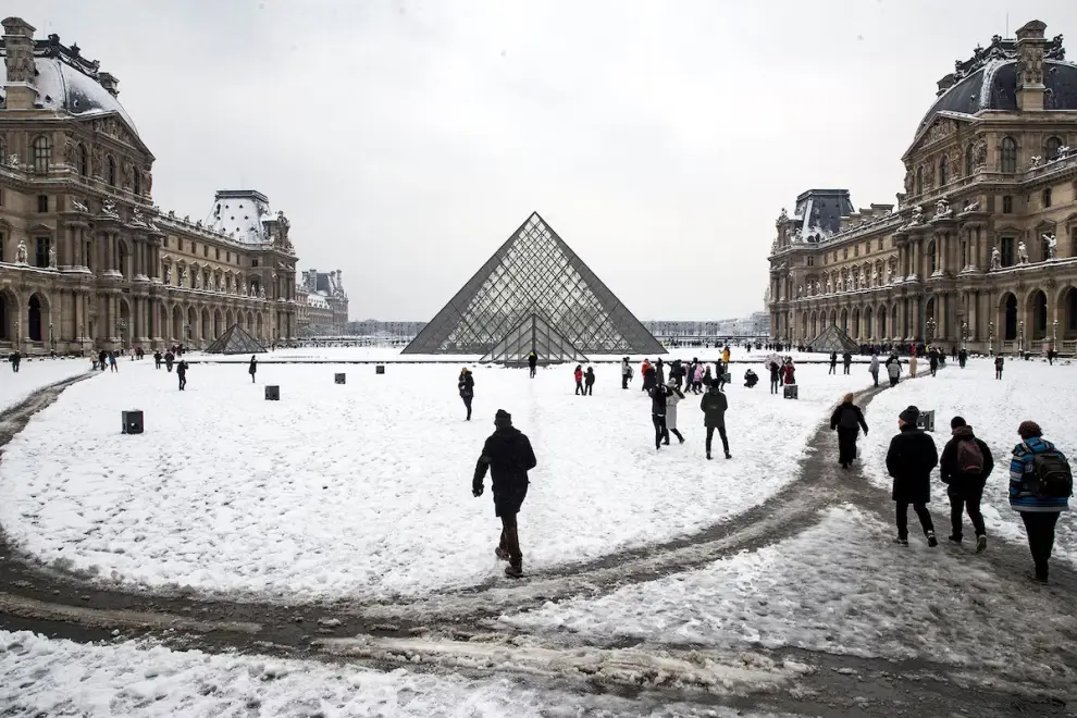 La pirámide del Louvre y los senderos dibujados en medio de la alfombra blanca parisina