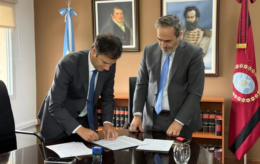 El Secretario de Justicia junto al Procurador, firmando el convenio.