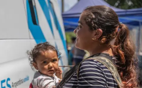 Mujer con su hija en brazos.