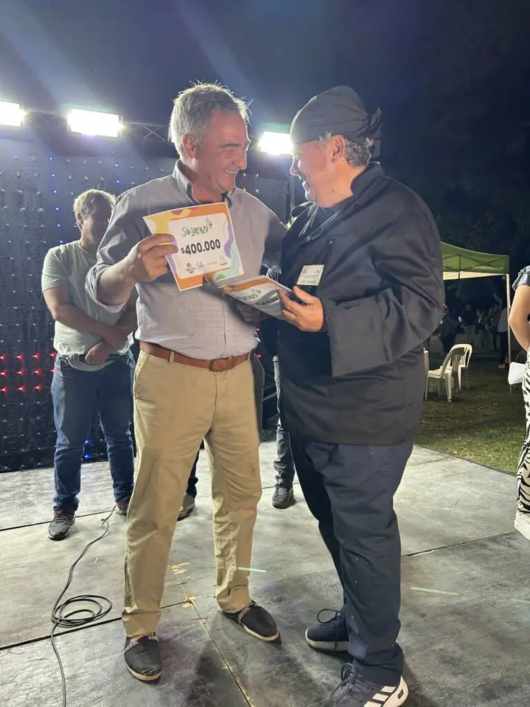 El intendente le entrega el premio al ganador del concurso