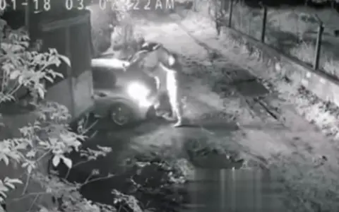 Los delincuentes cargando lo robado en un vehículo antes de huír.