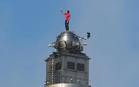 El escalador Alex Honnold en la cima del rascacielos de Taiwán