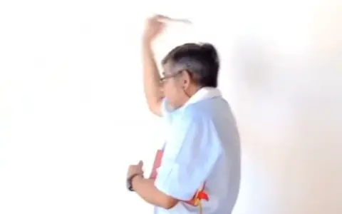 El padre Víctor Yurquina echando agua bendita en el edificio municipal