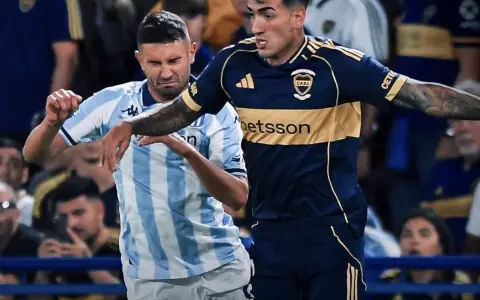 Luciano Di Lollo, de Boca, busca obstaculizar con sus brazos a Adrián "Maravilla" Martínez, de Racing, en un partido aburrido y somnoliento.