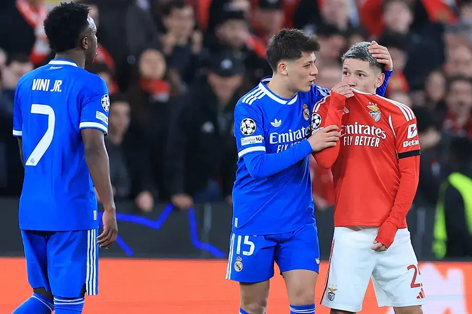 Gianluca Prestianni se dirige a Vinicius tapándose la boca con la camiseta.