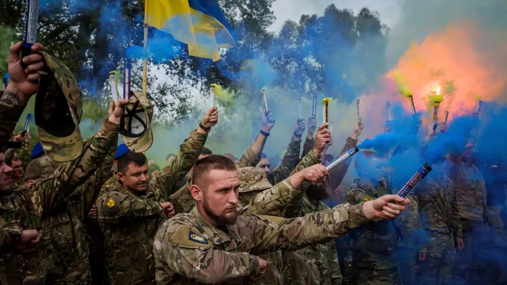 Militares ucranianos de la brigada Azov encienden bengalas durante la ceremonia fúnebre de un camarada caído