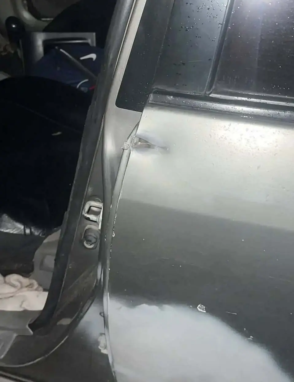 El impacto de disparo cerca de la puerta del conductor