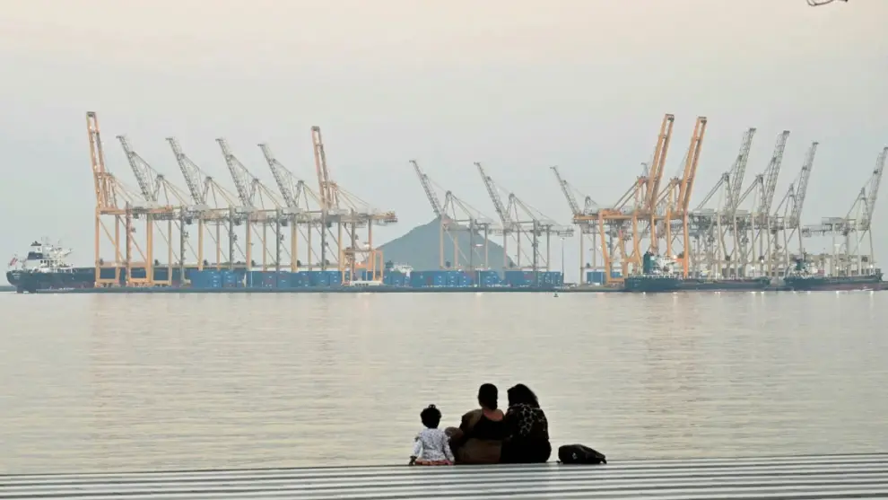 Una familia sentada frente a un astillero frente a la ciudad costera de Fujairah, en el estrecho de Ormuz.