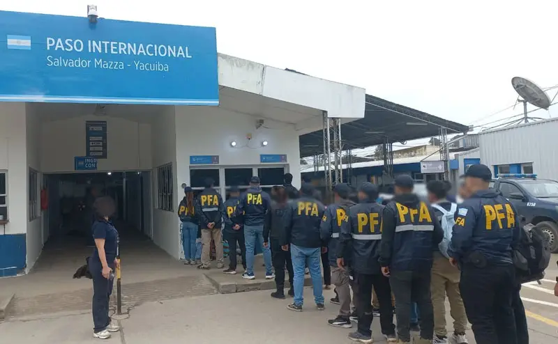 Efectivos de la Federal junto a las personas expulsadas.