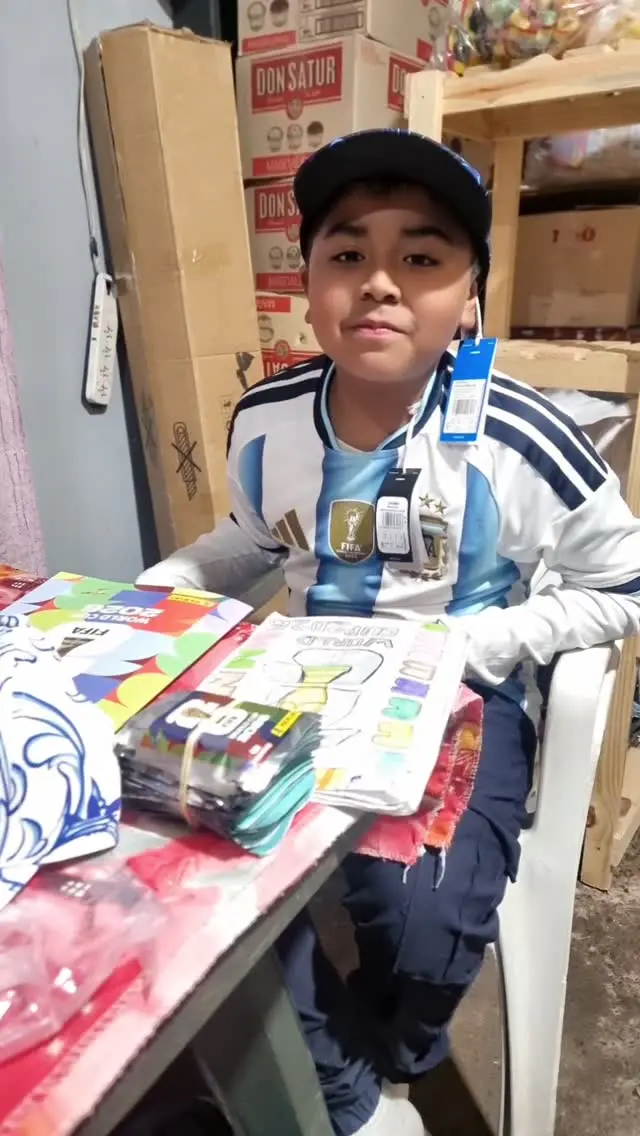 Dylan Lamas con el álbum y las figuritas que les regalaron de la AFA y el que dibujó él