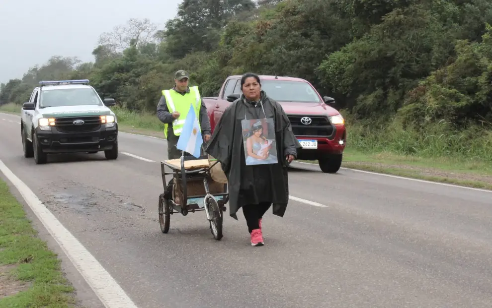 Mariana Aranda caminando por la ruta nacional 34 escoltada por Gendarmería Nacional.