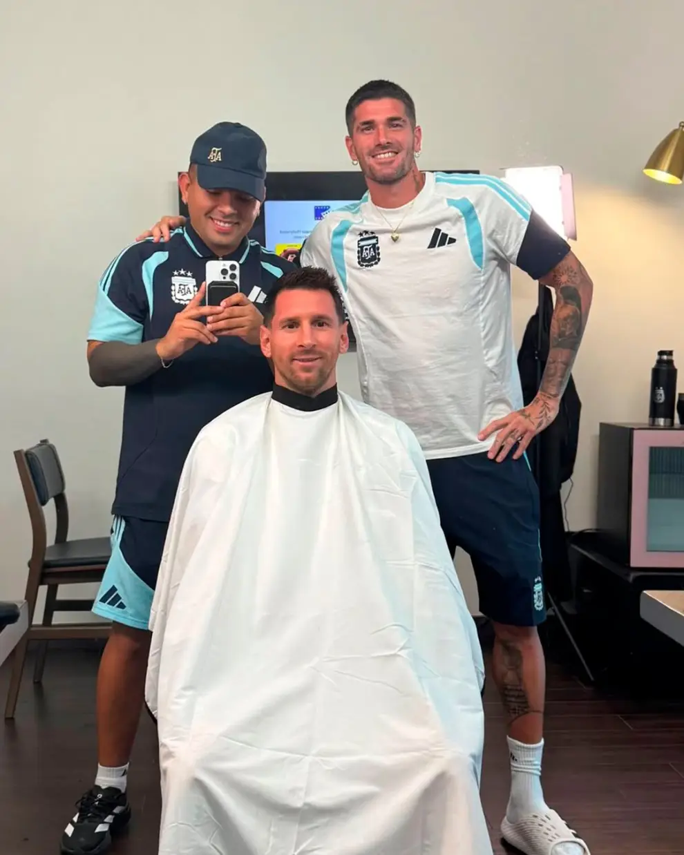 Lionel Messi, junto a su peluquero de confianza y Rodrigo De Paul.