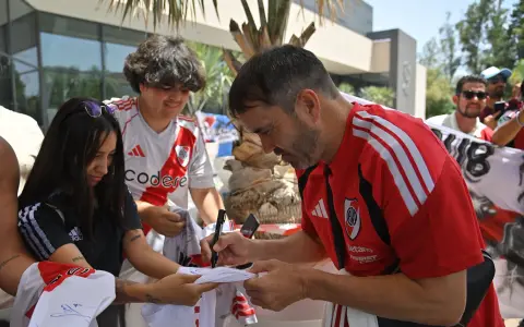 El Chacho Coudet firma autógrafos a hinchas de River en la puerta del hotel donde concentrará durante su estadía en suelo español.