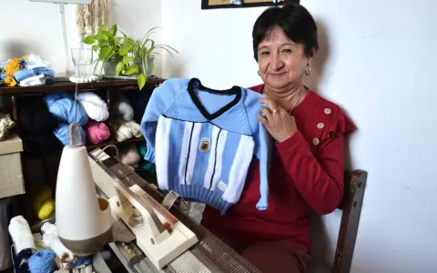 Sonia López mostrando uno de los pulóveres que hizo para su nieto más pequeño, con un diseño similar a la camiseta del Mundial 1998.