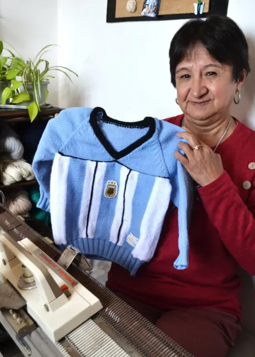 Sonia López mostrando uno de los pulóveres que hizo para su nieto más pequeño, con un diseño similar a la camiseta del Mundial 1998.