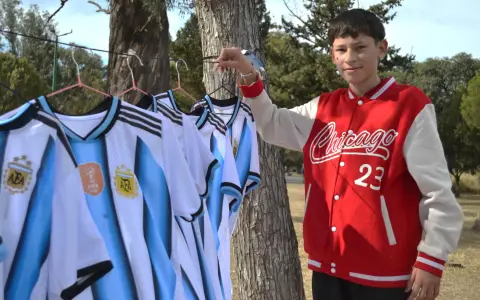 Pío Peñalva junto a las camisetas que vende para ayudar a su madre con cáncer.