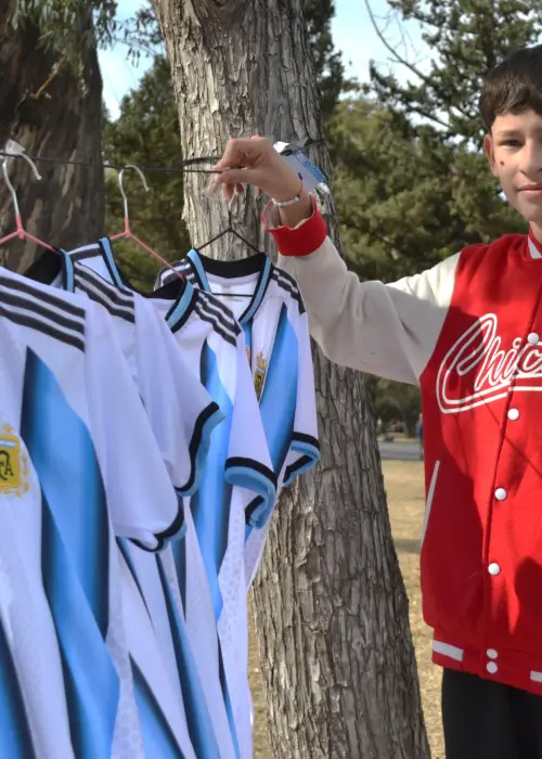Pío Peñalva junto a las camisetas que vende para ayudar a su madre con cáncer.