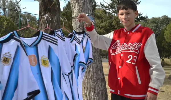 Pío Peñalva junto a las camisetas que vende para ayudar a su madre con cáncer.