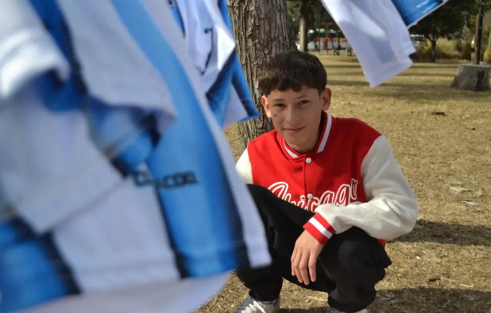 Pío Peñalva junto a las camisetas que vende para ayudar a su madre con cáncer.
