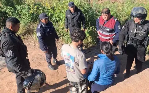 Efectivos policiales junto a los menores tras encontrarlos en una zona rural.